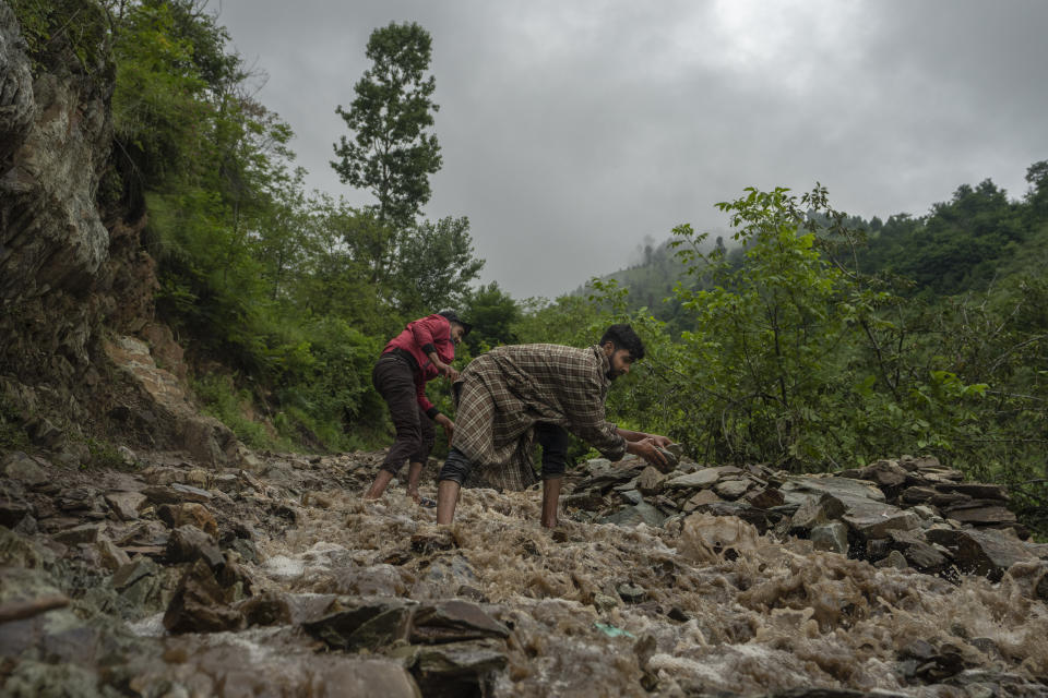 FILE - Kashmiri men pile rocks and boulders to stop floodwaters from entering their field after a cloudburst on the outskirts of Srinagar, Indian controlled Kashmir, July 22, 2023. Such intense rainfall events, especially when more than 10 centimeters (3.94 inches) of rainfall occurs within a 10 square kilometers (3.86 square miles) region within an hour are called cloudbursts and have potential to wreak havoc, causing intense flooding and landslides that affect thousands in mountain regions. (AP Photo/Dar Yasin, File)