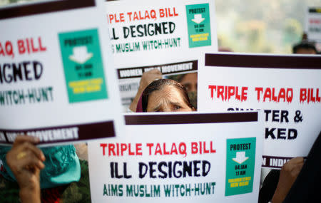 FILE PHOTO: Muslim women hold placards during a protest against a bill passed by India's lower house of Parliament last week that aims at prosecuting Muslim men who divorce their wives through the "triple talaq," or instant divorce, in New Delhi, India January 4, 2018. REUTERS/Adnan Abidi/File Photo