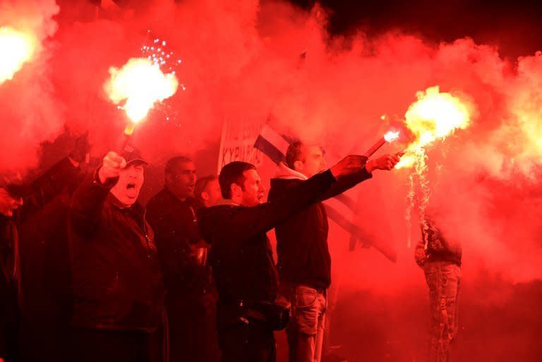 Some of about 1,000 members of the ultra-nationalist Golden Dawn party hold flares as they protest in Athens on March 22, 2013. Greek Prime Minister Antonis Samaras on Thursday said he would not allow neo-Nazi party Golden Dawn to "undermine" democracy after one of its alleged supporters fatally stabbed a popular anti-fascist musician