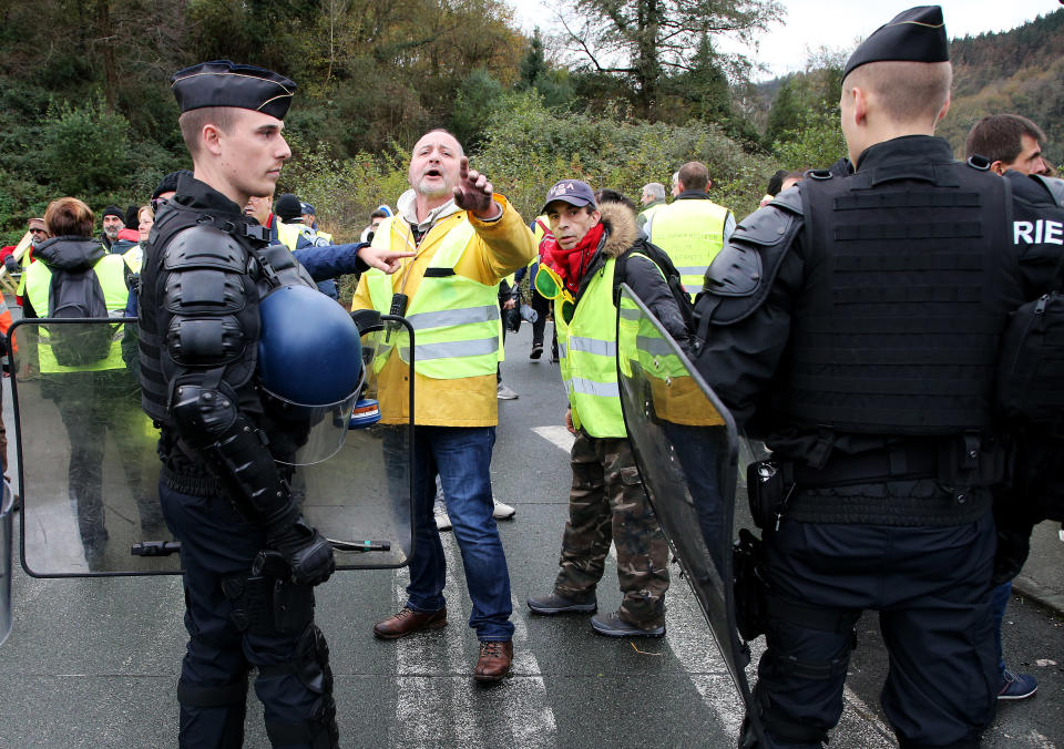 French police officers evacuate demonstrators wearing yellow vests near the French Spanish border in Biriatou during a protest Saturday, Dec. 15, 2018 in Biriatou, southwestern France. Police are deployed in large numbers Saturday for the fifth straight weekend of demonstrations by the "yellow vest" protesters, with authorities repeating calls for calm after protests on previous weekends turned violent. (AP Photo/Bob Edme)