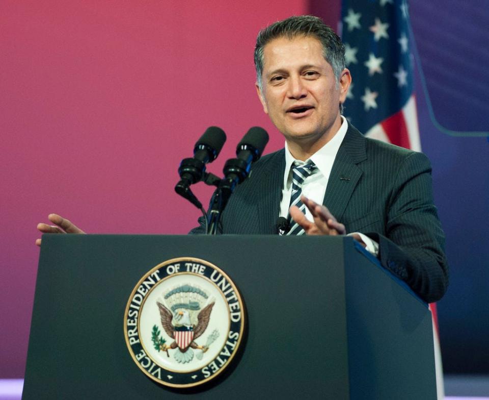 Joe Kiani behind a podium with a US government seal on it in front of an American flag