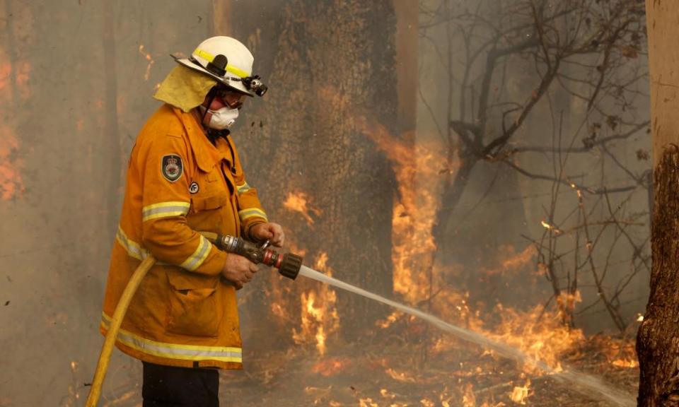 A Tuncurry firefighter battles a bushfire south of Taree, in New South Wales, on 12 November.