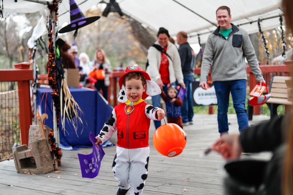 Bennett Mcilravy, 3 runs to volunteer and Indianola senior Carly Richards during the Night Eyes, a Merry-Not-Scary Halloween Tradition at Blank Park Zoo last year.