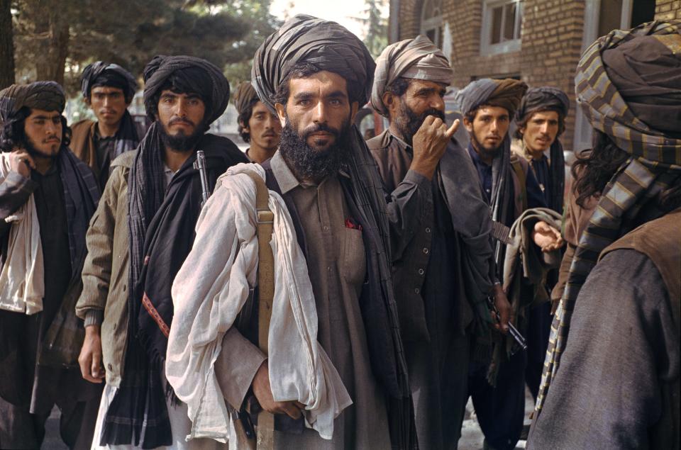 A row of Taliban fighters face the camera