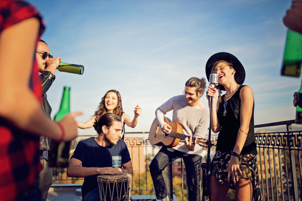 group of young people singing and playing instruments on a rooftop