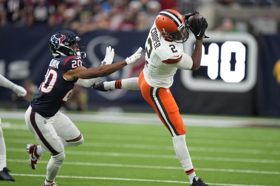 Cleveland Browns wide receiver Amari Cooper (2) catches a pass as Houston Texans cornerback Ka'dar Hollman (20) defends during the first half of an NFL football game Sunday, Dec. 24, 2023, in Houston. (AP Photo/Eric Christian Smith)