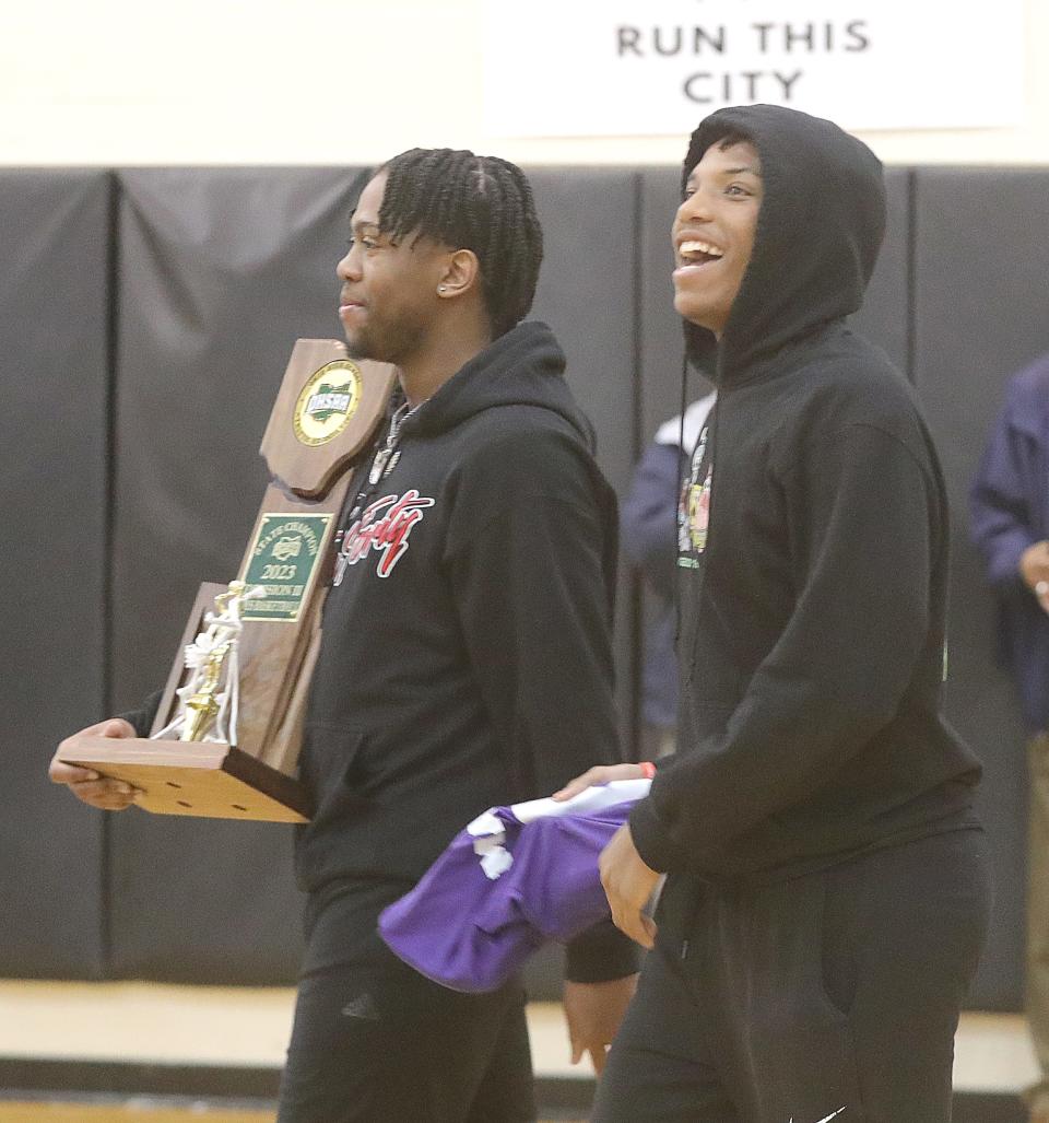 Buchtel High School basketball players Tajh Poole, left, and Damien Johnson lead the Griffins into a school assembly to celebrate their Division II state championship, Wednesday, March 22, 2023.