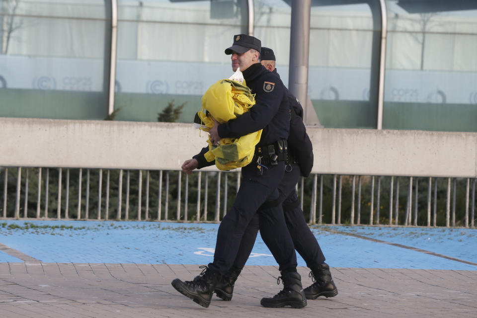 Police take away one of the banners that Greenpeace activists tried to display outside the COP25 climate talks congress in Madrid, Spain, Friday, Dec. 13, 2019. The United Nations Secretary-General has warned that failure to tackle global warming could result in economic disaster. (AP Photo/Paul White)