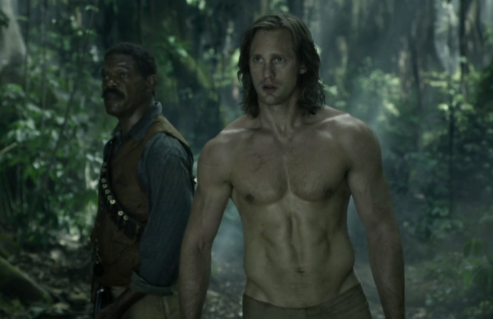 Alexander shirtless in the jungle, standing next to Samuel L. Jackson's character