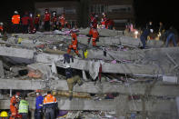 Members of rescue services search in the debris of a collapsed building for survivors in Izmir, Turkey, early Saturday, Oct. 31, 2020. A strong earthquake struck Friday in the Aegean Sea between the Turkish coast and the Greek island of Samos, killing several people and injuring hundreds amid collapsed buildings and flooding. (AP Photo/Emrah Gurel)