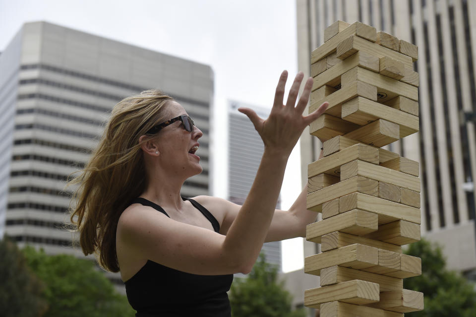 DENVER, CO - JUNE 10: Tammy Muse reacts as a gust of wind knocks over a giant jenga tower before she could make her move at Skyline Park in Denver, Colorado on June 10, 2016. Denver is looking to activate the 16th Street Mall this summer, more so than in previous years. (Photo by Seth McConnell/The Denver Post via Getty Images)