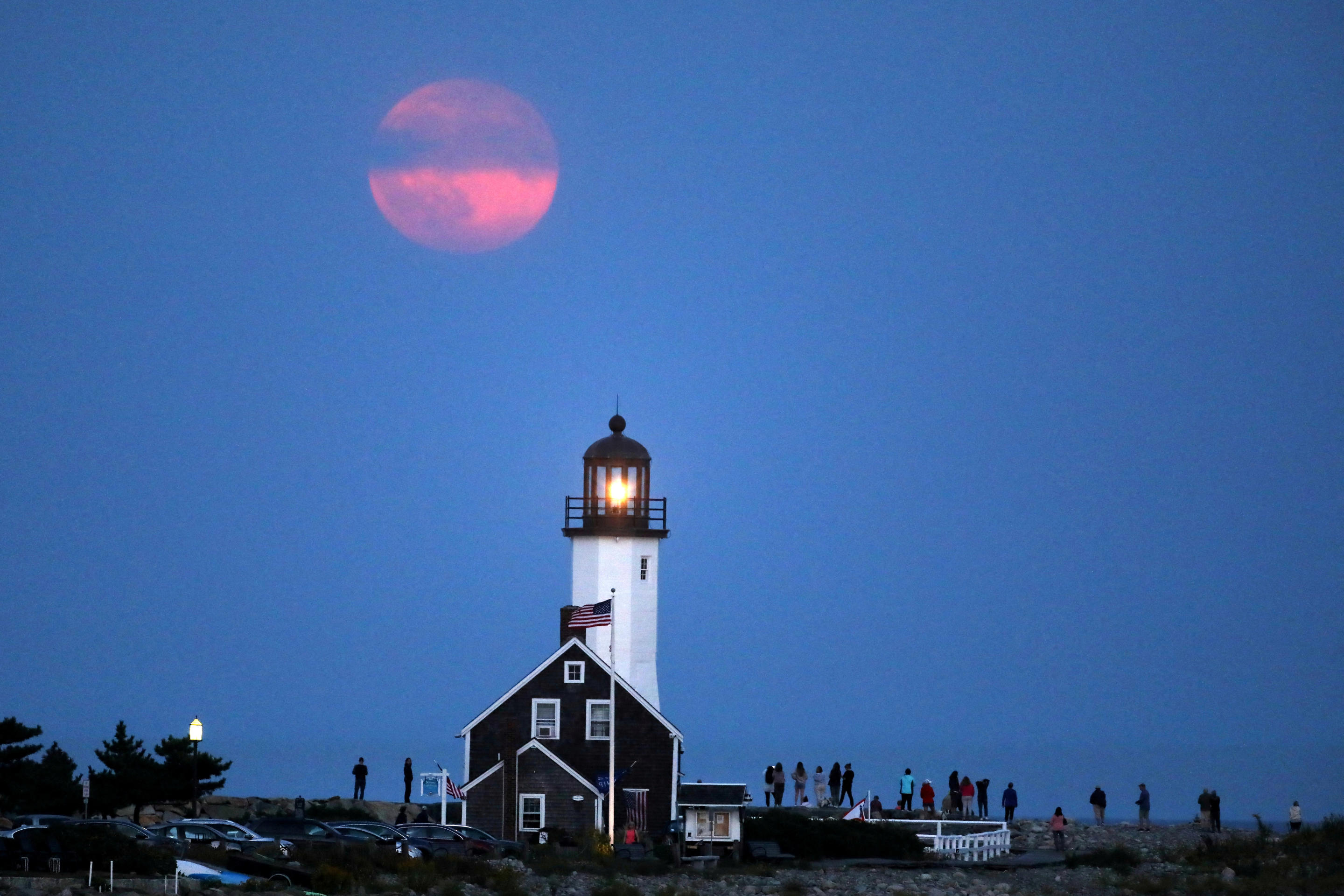 A Harvest supermoon rises over a lighthouse in Scituate, Mass., on Sept. 17 (Lauren Owens Lambert/Reuters)