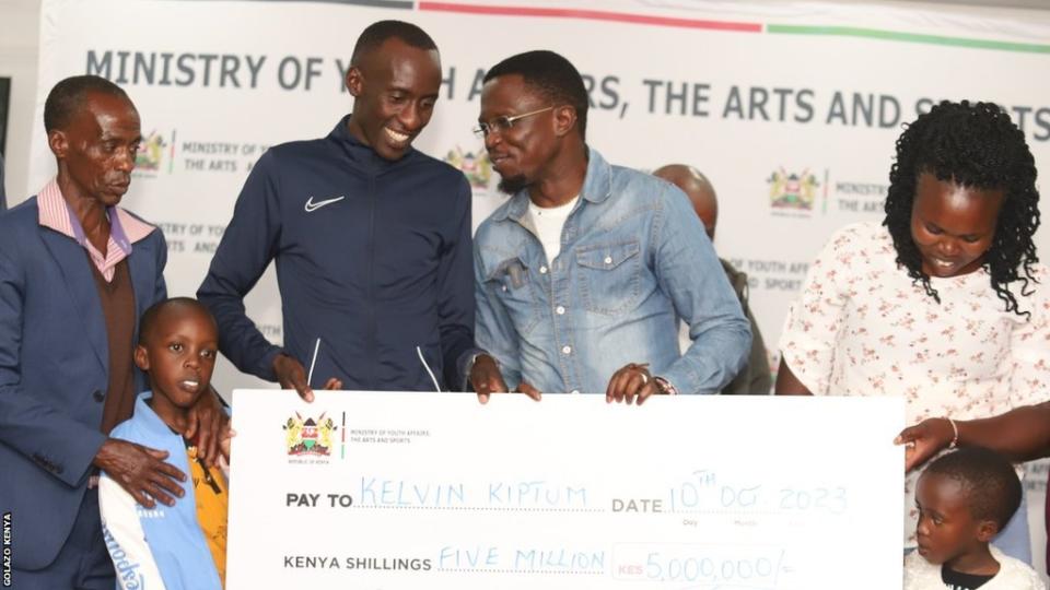 Отец, жена и дети бегуна и рекордсмена мира по марафону Кельвина Киптума присоединились к нему, чтобы принять правительственную награду от министра спорта Кении.