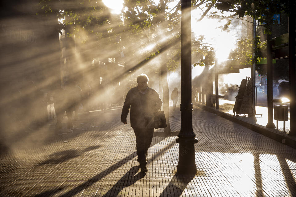 A pedestrian quickens his pace to escape the fumes caused by tear gas tear launched by police during a protest against the rising cost of subway and bus fares, in Santiago, Friday, Oct. 18, 2019. (Photo: Esteban Felix/AP)