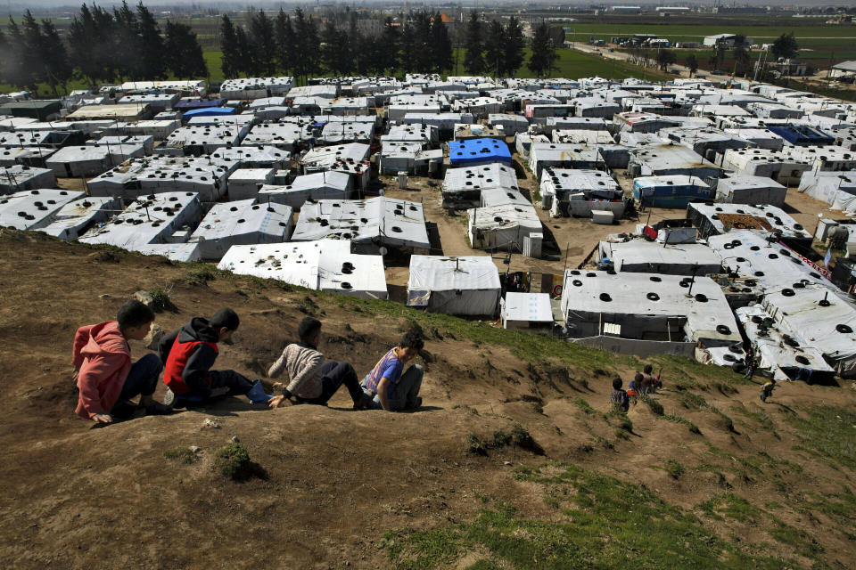 FILE - displaced Syrian children slide down a hill, above a refugee camp in the town of Bar Elias, in Lebanon's Bekaa Valley, March 12, 2019. Against the backdrop of a worsening economic crisis and political stalemate, Lebanese officials have launched a crackdown on the country's Syrian refugees. (AP Photo/Bilal Hussein, File)