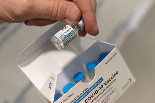 A pharmacist holds a vial of Johnson & Johnson COVID-19 vaccine.