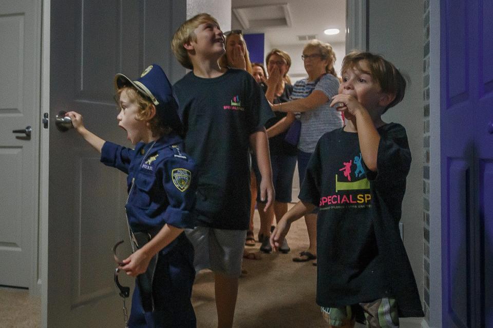 Four-year-old Caedyn Jynella, left, sees his new law enforcement-themed bedroom with his older brothers Gavin Fairbanks, 8, center, and Keenan Jynella, 5, during a press event July 17 at their home in Riviera Beach. The Boca Raton chapter of Special Spaces fulfilled Jynella's wish for the room. Jynella lost sight in a one eye from an optic glioma brain tumor.