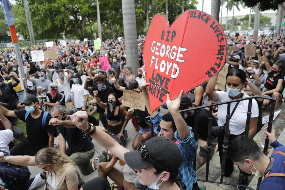 People kneel during a protest over the death of George Floyd, Saturday, June 6, 2020, in Miami. Protests continue throughout the country over the death of Floyd, a black man who died after being restrained by Minneapolis police officers on May 25 (AP Photo/Lynne Sladky)