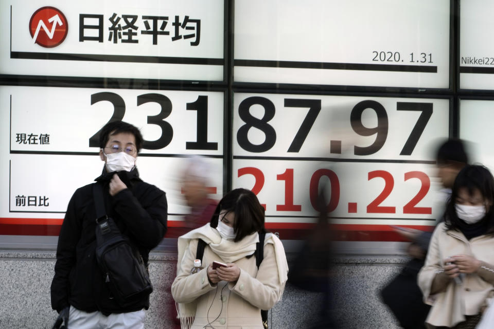 People stand near an electronic stock board showing Japan's Nikkei 225 index at a securities firm in Tokyo Friday, Jan. 31, 2020. Shares are mixed in Asia after the World Health Organization declared the outbreak of a new virus that has spread from China to more than a dozen countries a global emergency. (AP Photo/Eugene Hoshiko)