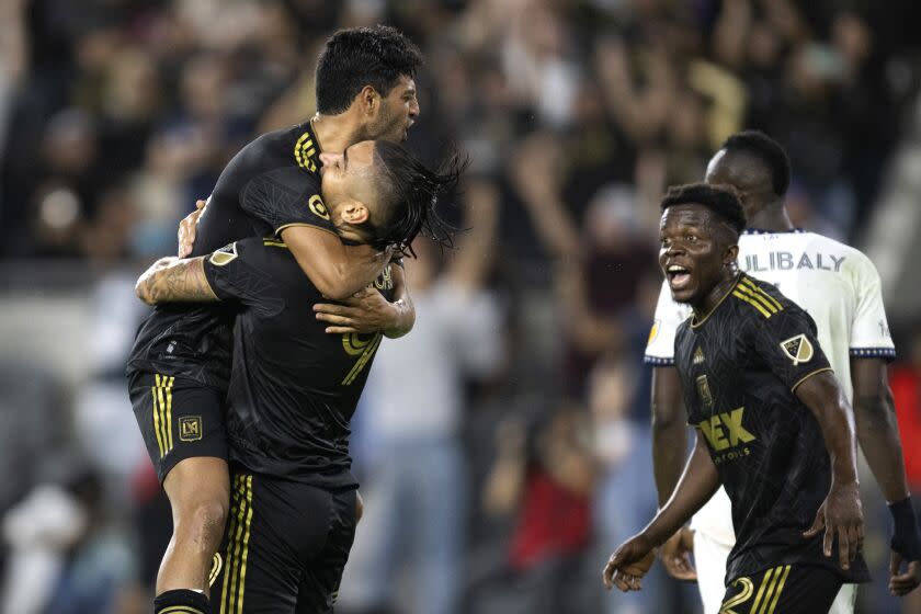Los Angeles FC forward Cristian Arango, center, celebrates his gaol with forward Carlos Vela during the second half of the team's MLS soccer match against the LA Galaxy in Los Angeles, Friday, July 8, 2022. (AP Photo/Kyusung Gong)