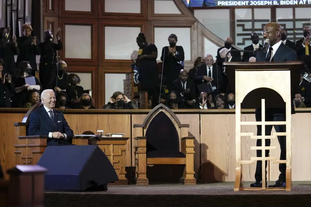 (L-R) President Joe Biden listens on Jan. 15, 2023 as Sen. Raphael Warnock, D-Ga., a senior pastor of Ebenezer Baptist Church, speaks during a service honoring Martin Luther King Jr. at the Atlanta church. (AP Photo/Carolyn Kaster)