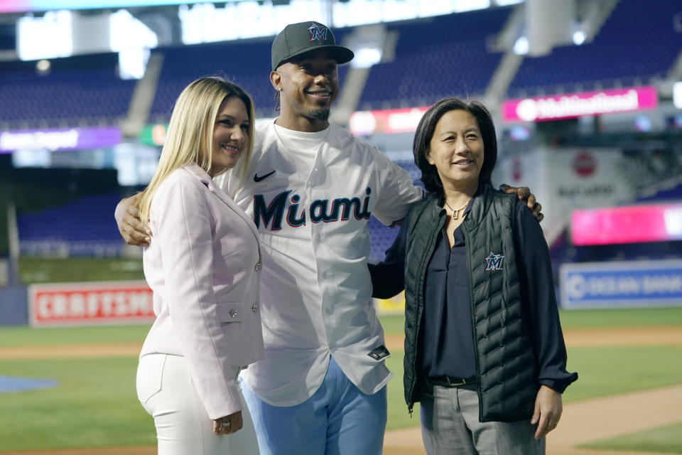 Miami Marlins baseball infielder Jean Segura, center, wears a Marlins jersey as he poses for a photograph with his wife Kellen, left, and Marlins General Manager Kim Ng, right, Wednesday, Jan. 11, 2023, in Miami. Segura recently signed a two-year deal with the Marlins. (AP Photo/Lynne Sladky)