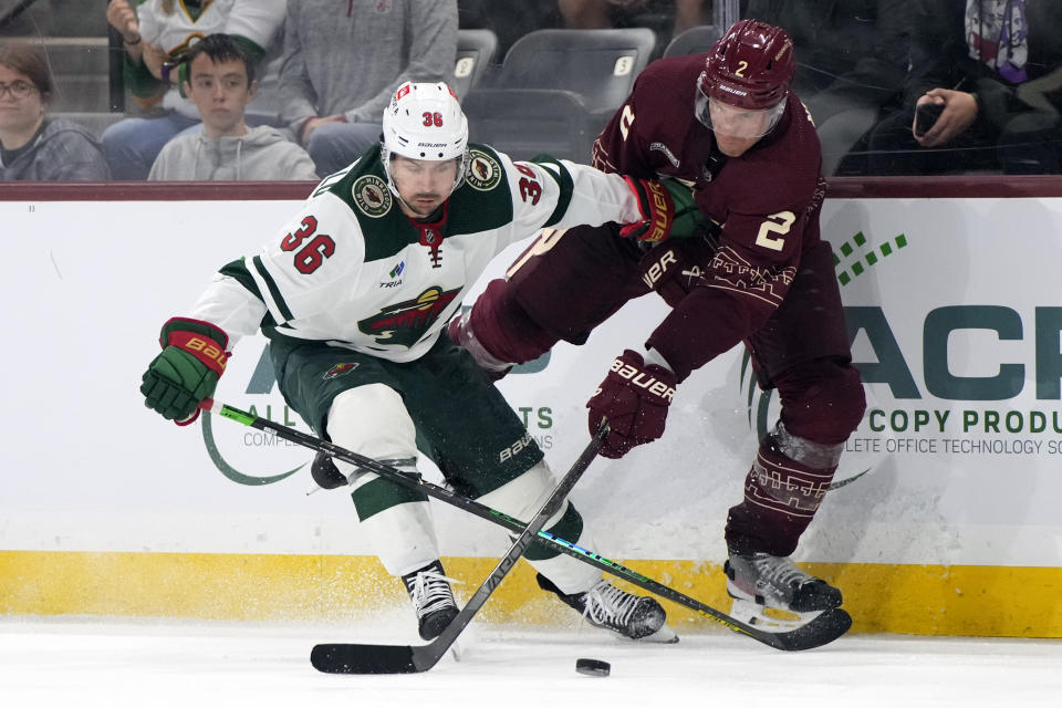 Minnesota Wild right wing Mats Zuccarello (36) and Arizona Coyotes defenseman Patrik Nemeth (2) fight for the puck during the third period of an NHL hockey game, Sunday, March 12, 2023, in Tempe, Ariz. Arizona won 5-4 in overtime. (AP Photo/Rick Scuteri)