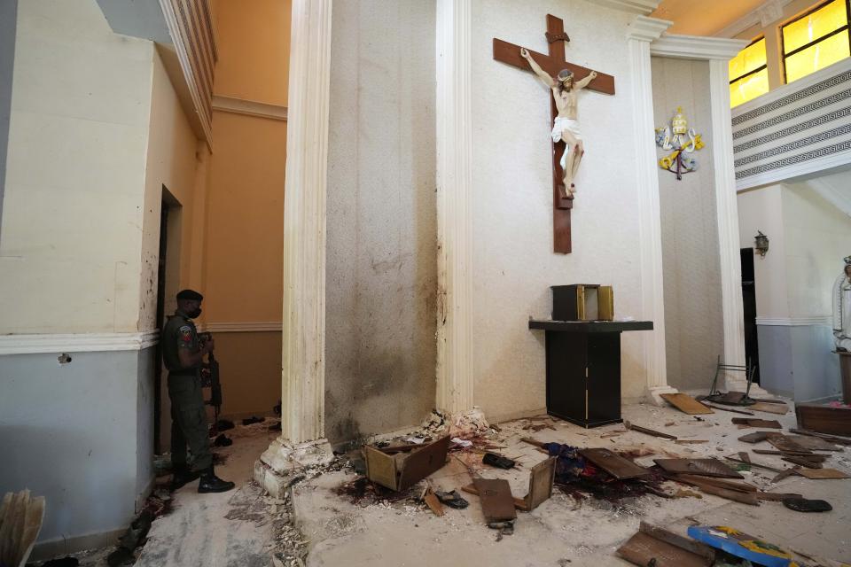 A police officer stands guard inside the St. Francis Catholic Church, a day after an attack that targeted worshipers in Owo, Nigeria, Monday, June 6, 2022. The gunmen who killed 50 people at a Catholic church in southwestern Nigeria opened fire on worshippers both inside and outside the building in a coordinated attack before escaping the scene, authorities and witnesses said Monday. (AP Photo/Sunday Alamba)