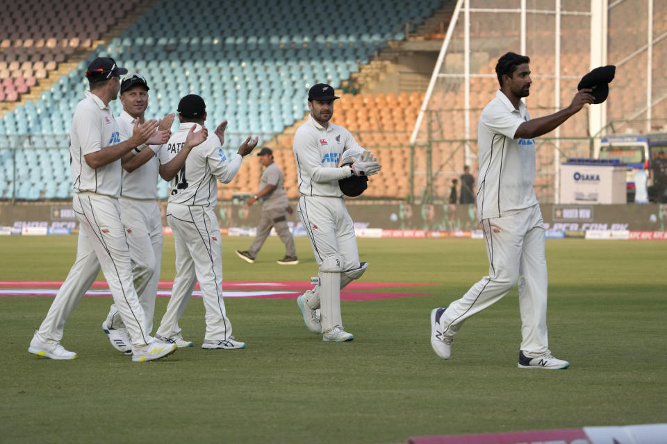 New Zealand's players clap for teammate Ish Sodhi, right, who took 7 wickets in second innings, as they walk off the field on the end of Pakistan's innings during the fifth day of first test cricket match between Pakistan and New Zealand, in Karachi, Pakistan, Friday, Dec. 30, 2022. (AP Photo/Fareed Khan)