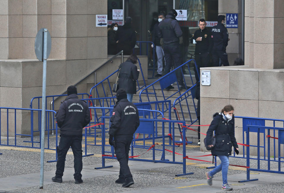 Police officers provide security outside a court where the case against Can Dundar, the editor-in-chief of opposition newspaper Cumhuriyet on espionage and terror-related charges, was held, in Istanbul, Wednesday, Dec. 23, 2020. The court in Istanbul on Wednesday found Dundar, in exile in Germany, guilty of “obtaining secret documents for espionage” and “aiding a terrorist organization,” sentencing him to a total of 27 1/2 years in prison. (AP Photo/Mehmet Guzel)