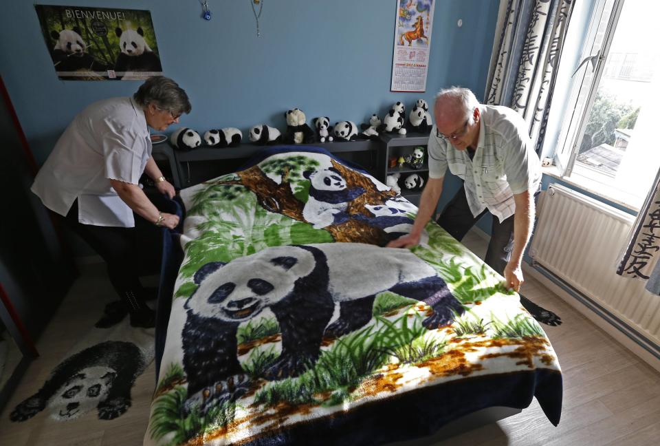 Celine and Andre Cornet adjust a blanket, part of their collection of 2,200 pieces of panda collectables, in their house in Haccourt March 11, 2014. REUTERS/Yves Herman