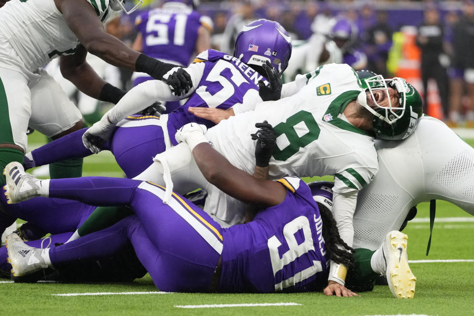 New York Jets quarterback Aaron Rodgers (8), right, reacts as he is tackled during the second half of an NFL football game against the Minnesota Vikings, Sunday, Oct. 6, 2024, at the Tottenham Hotspur stadium in London. (AP Photo/Kirsty Wigglesworth)