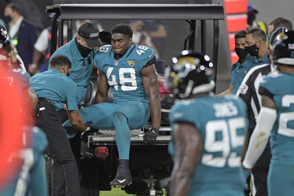 Teammates watch as Jacksonville Jaguars outside linebacker Leon Jacobs (48) is taken off the field after he was injured during the first half of an NFL football game against the Miami Dolphins, Thursday, Sept. 24, 2020, in Jacksonville, Fla. (AP Photo/Phelan M. Ebenhack)