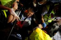 A journalist reacts after being hit with tears gas during an anti-government protest at Mong Kok in Hong Kong