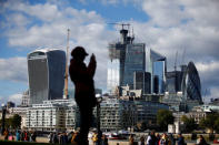 A person takes a photograph with the financial district in the background, in London, Britain, September 23, 2018. REUTERS/Henry Nicholls