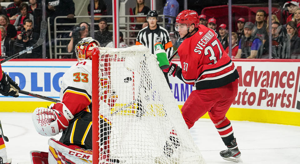 RALEIGH, NC - OCTOBER 29: Carolina Hurricanes Left Wing Andrei Svechnikov (37) uses a lacrosse move to lift the puck behind Calgary Flames Goalie David Rittich (33) during a game between the Calgary Flames and the Carolina Hurricanes at the PNC Arena in Raleigh, NC on October 29, 2019. (Photo by Greg Thompson/Icon Sportswire via Getty Images)