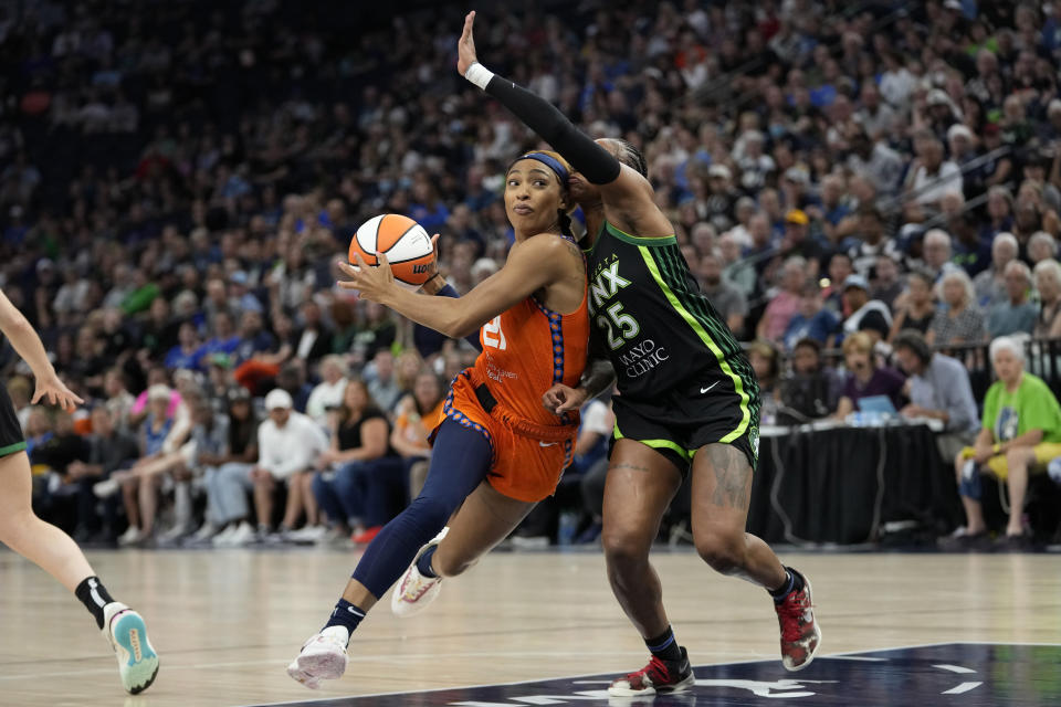 Connecticut Sun guard DiJonai Carrington, left, works toward the basket while defended by Minnesota Lynx guard Tiffany Mitchell during the first half of Game 3 of a WNBA first-round basketball playoff series Wednesday, Sept. 20, 2023, in Minneapolis. (AP Photo/Abbie Parr)