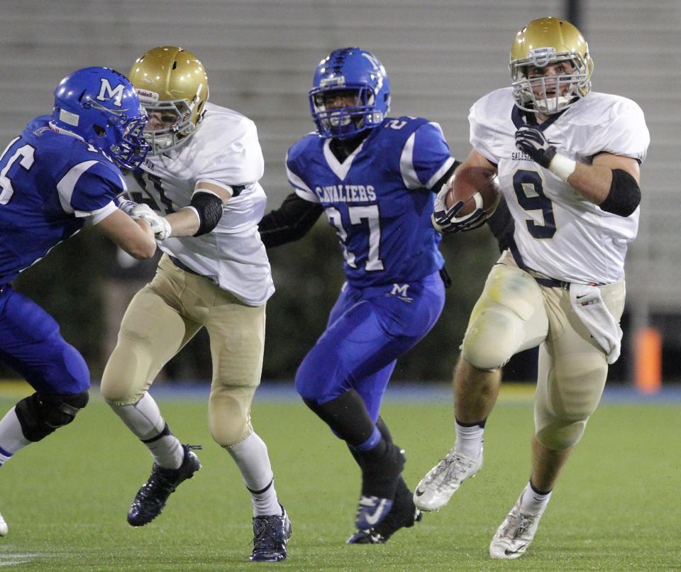 Salesianum's Troy Reeder, right, picks up yards in the second quarter behind a block by Zach Jarome, second from left, in November 2013.