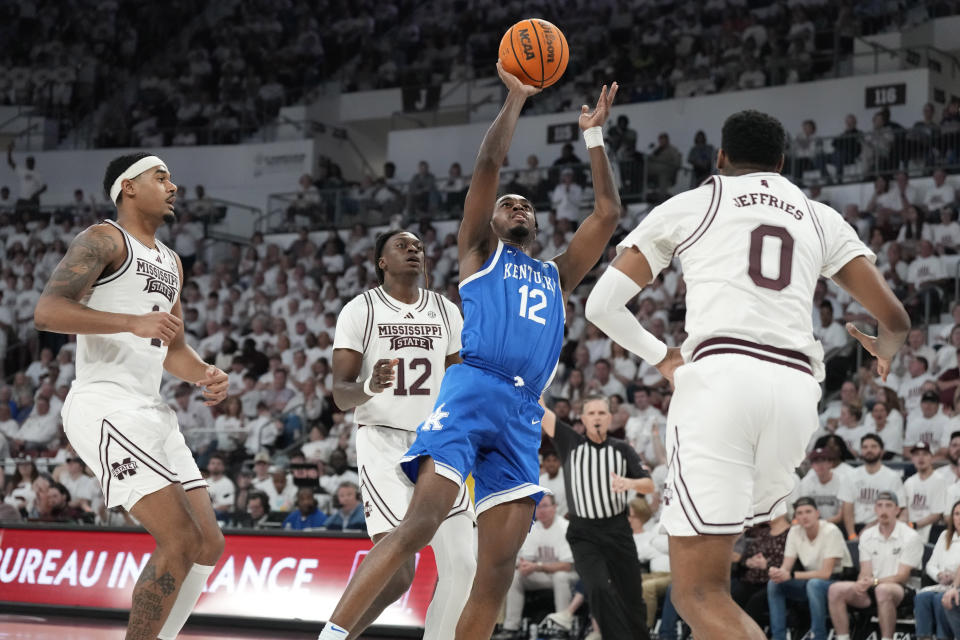 Kentucky guard Antonio Reeves (12) shoots while guarded by Mississippi State forwards Tolu Smith, left, KeShawn Murphy (12) and D.J. Jeffries (0) during the second half of an NCAA college basketball game Tuesday, Feb. 27, 2024, in Starkville, Miss. (AP Photo/Rogelio V. Solis)