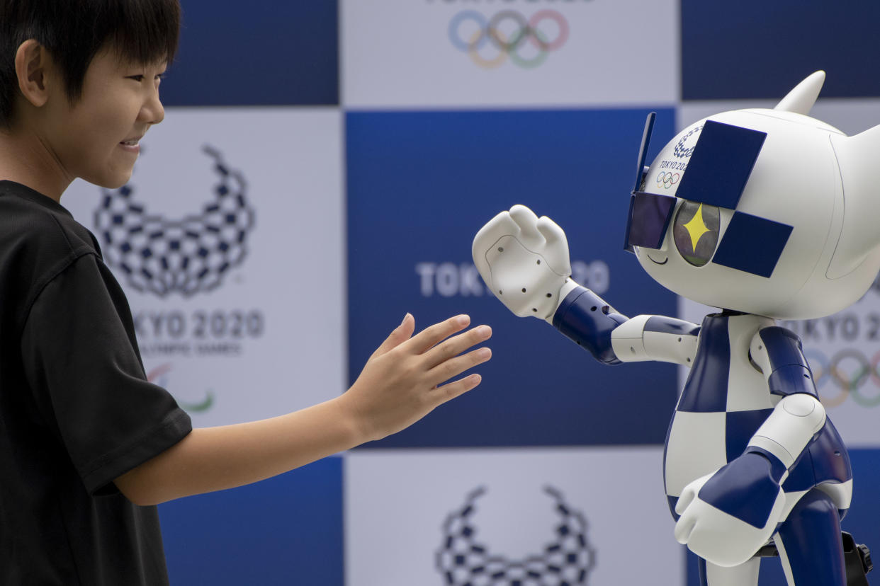 A boy shakes hands with Tokyo 2020 mascot robot Miraitowa at Tokyo Stadiuam in Chofu, on the outskirts of Tokyo, Japan, 22 July 2019. The ceremony took place prior to the 'One Year To Go Tokyo 2020' ceremony on 24 July 2019. The Tokyo 2020 Olympics will take place from 24 July 2020 through 09 August 2020. The Tokyo 2020 Organising Committee of the Olympic and Paralympic Games unveiled the mascot robot Miraitowa, developed by Toyota Motor Corp. (Photo by Alessandro Di Ciommo/NurPhoto via Getty Images)