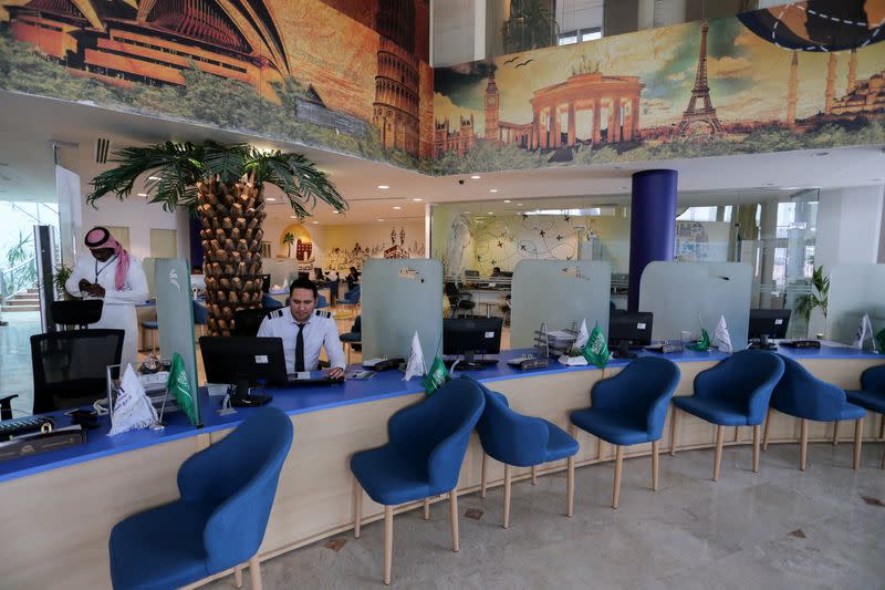 Employees sit behind their desks, as they wait for customers at a travel agency in Riyadh