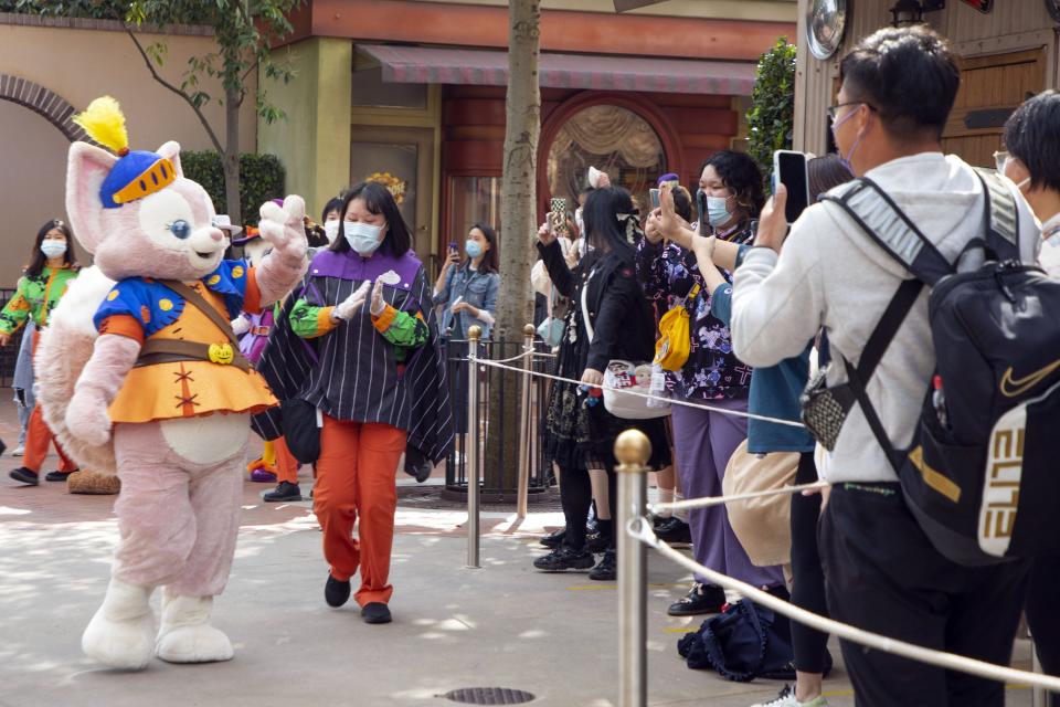 A staff member dressed as LinaBell waves to visitors at Shanghai Disneyland.