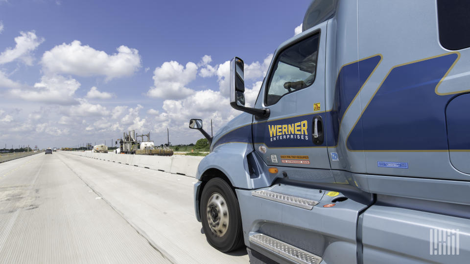 A side view of a blue Werner tractor on the highway