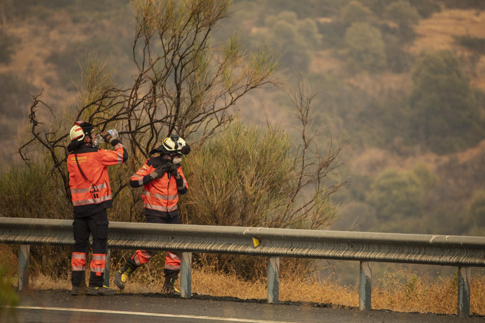 Forest firefighters work in a wildfire in Estepona, Spain, Thursday, Sept. 9, 2021. Nearly 800 people have been evacuated from their homes and road traffic has been disrupted as firefighting teams and planes fight a wildfire in southwestern Spain. (AP Photo/Sergio Rodrigo)