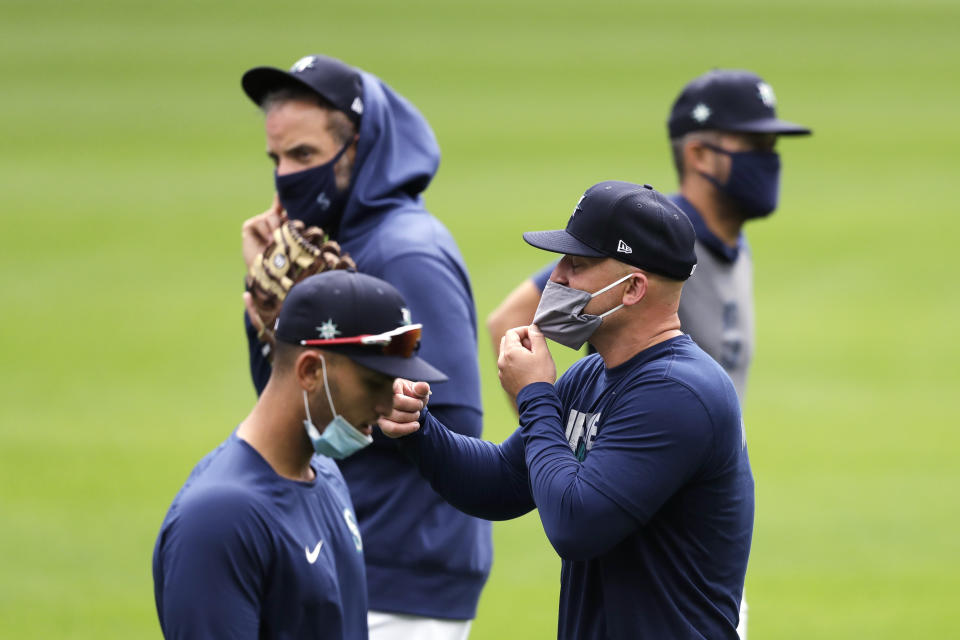 Seattle Mariners' Kyle Seager, second right, and teammates wear masks as they walk on the field at baseball practice Tuesday, July 7, 2020, in Seattle. (AP Photo/Elaine Thompson)