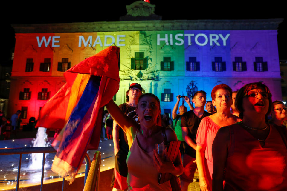 People celebrate in front of the rainbow-colour lit Auberge de Castille, the office of Prime Minister Joseph Muscat, after the Maltese parliament voted to legalise same-sex marriage on the Roman Catholic Mediterranean island, in Valletta, Malta, July 12, 2017.  REUTERS/Darrin Zammit Lupi