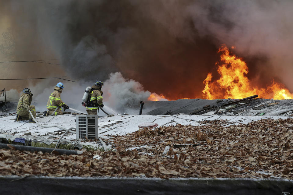 Firefighters battle a fire at Guryong village in Seoul, South Korea, Friday, Jan. 20, 2023. About 500 South Koreans were forced to flee their homes after a fire spread through a low-income neighborhood in southern Seoul on Friday morning and destroyed dozens of homes. (Baek Dong-hyun/Newsis via AP)