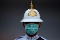 A Thai Royal Guard wears a mask while he stands inside the Royal Palace in Bangkok