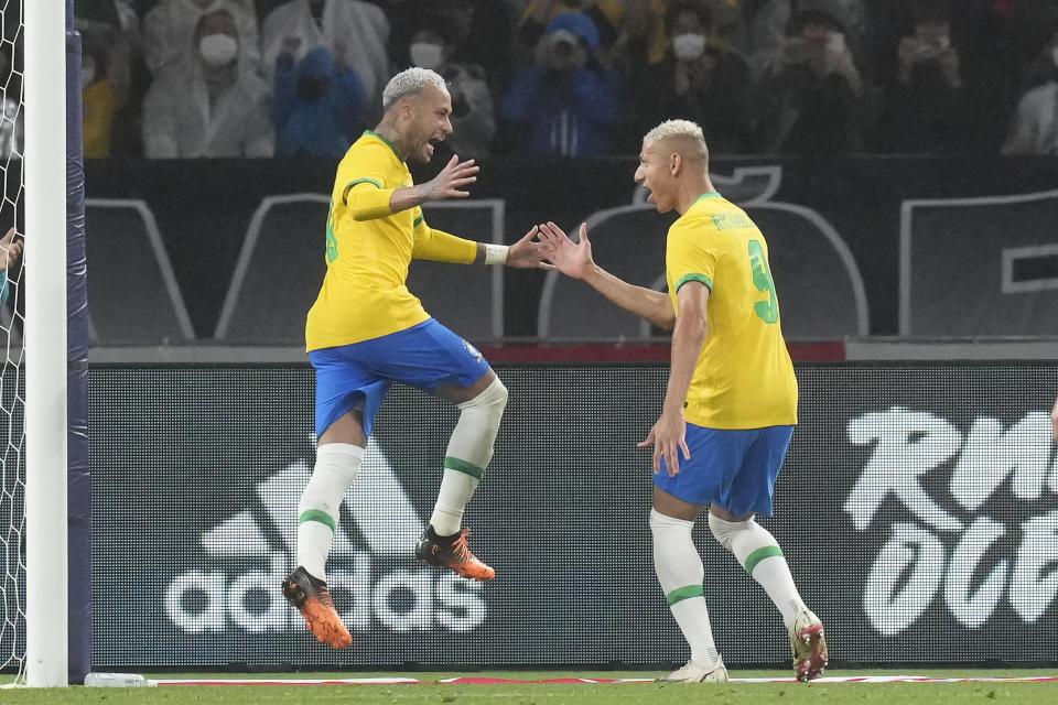 Neymar of Brazil, left, reacts with his teammate Richarlison of Brazil after scored during the friendly match at the National Stadium in Tokyo Monday, June 6, 2022. (AP Photo/Eugene Hoshiko)