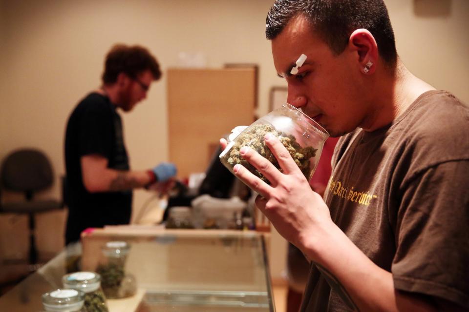 Un paciente de marihuana medicinal huele un frasco de hierbas antes de decidir qué dosis comprar en el River Rock Medical Marijuana Center en Denver, Colorado, el 16 de mayo de 2013. (Anthony Souffle / Chicago Tribune / MCT)